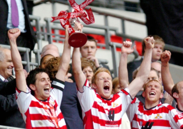Brian Stock (left) and Adam Lockwood hold the League One play-off trophy aloft following the 1-0 victory over Leeds United